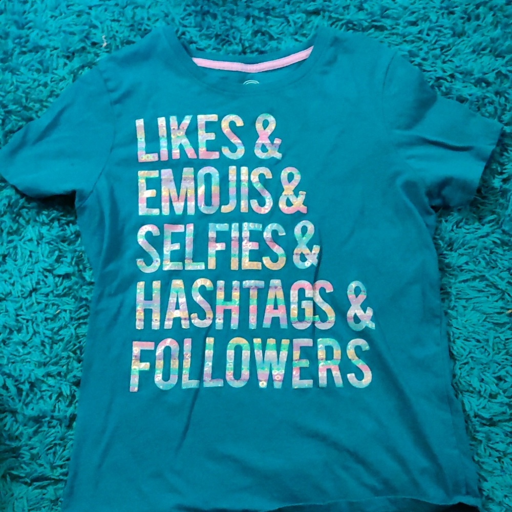 A teal t-shirt with hollographic letters